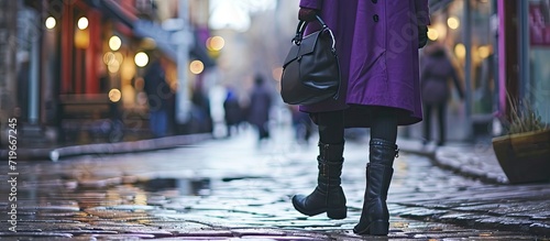 Young woman legs in black ankle boots and purple coat with bag Trendy hipster outfit. Copy space image. Place for adding text photo