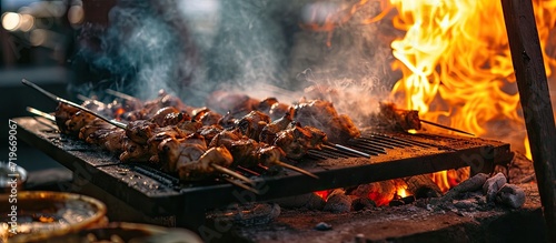 Selective focus of grilled kebab or chicken skewers picnic food cooking on outdoor bbq grill with fire flames and smoke in outdoor restaurant food outdoor kitchen. Copy space image photo