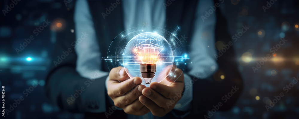 Businessman hands with lightbulb on wide background.