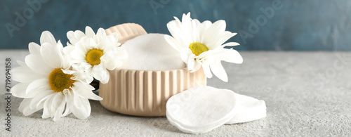 Cotton pads and chamomile flowers on grunge background