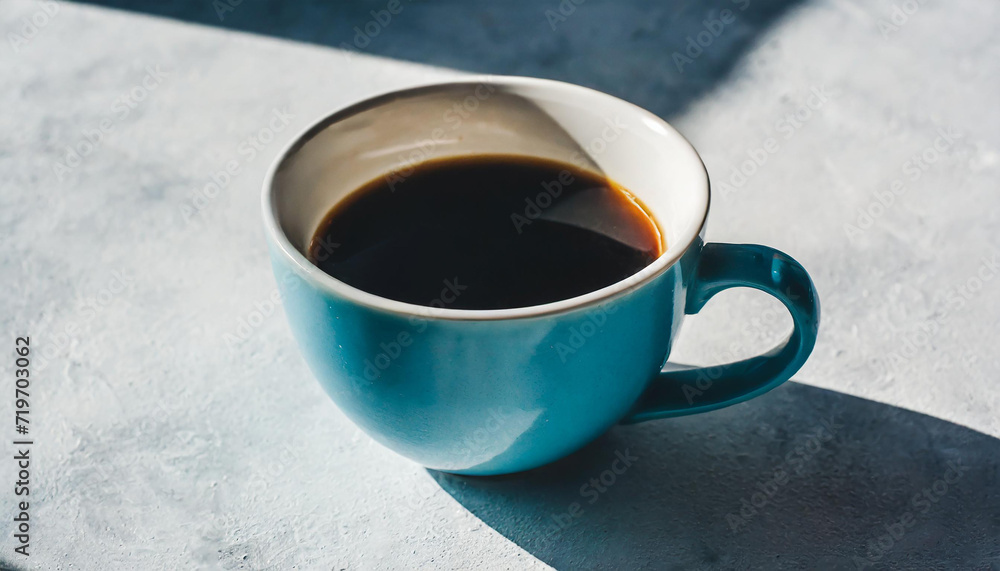 One cup of black coffee on a light background with a hard shadow. One cup of black coffee on a light background with a hard shadow.