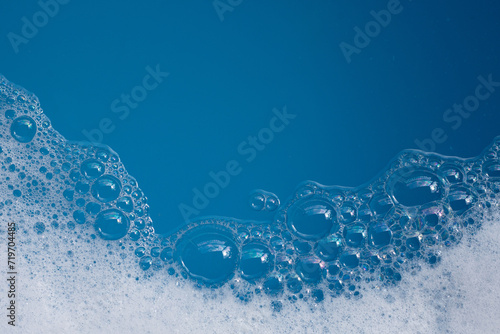Detergent foam bubble on water. Blue background, Soap sud