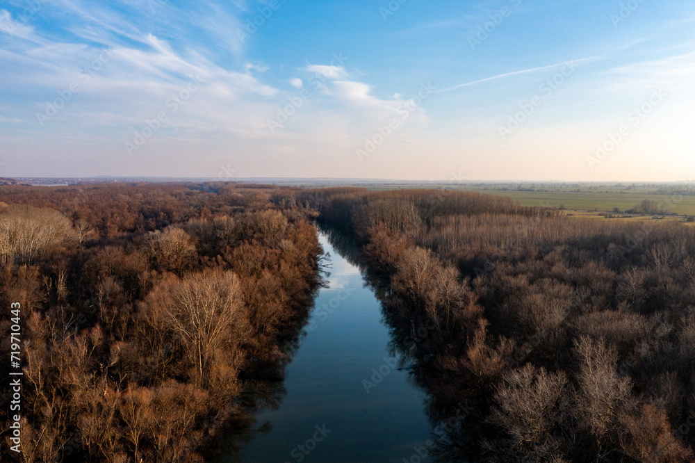 Riverside Reflections: Aerial Snapshot of Danube and Forest Under Sky