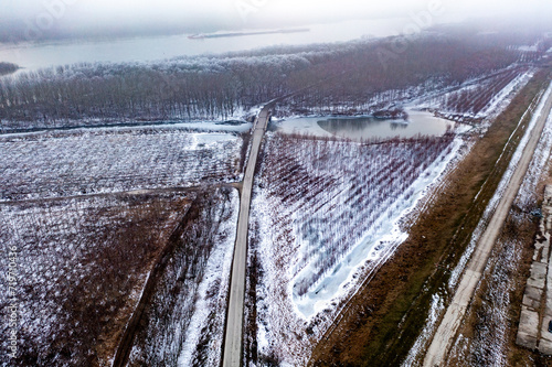 Winter Drive: Aerial View of Road Through Snowy Forest