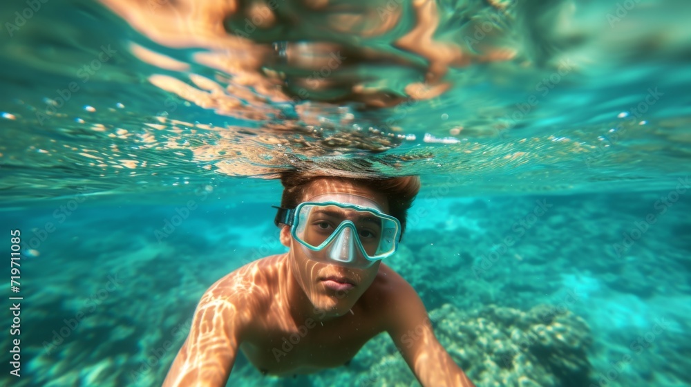Young man snorkeling in clear tropical turqoise waters