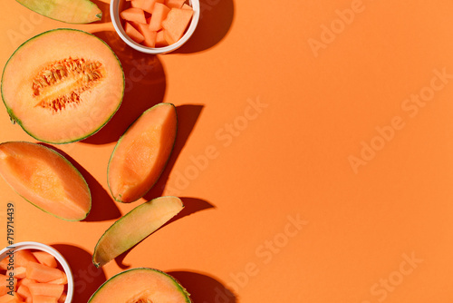 Tableau sur toile Sweet melons and bowls with pieces on orange background