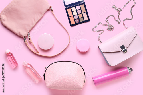 Composition with female bags and cosmetic products on pink background