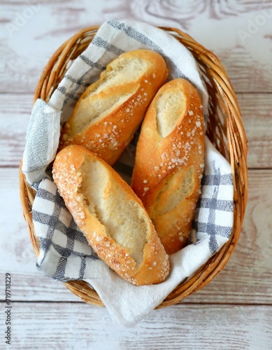 CESTO DE BAGUETES DE PÃO FRANCÊS CASEIRO SERVIDO EM UM AMBIENTE ACONCHEGANTE photo