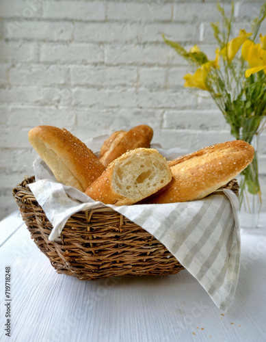 CESTO DE BAGUETES DE PÃO FRANCÊS CASEIRO SERVIDO EM UM AMBIENTE ACONCHEGANTE photo