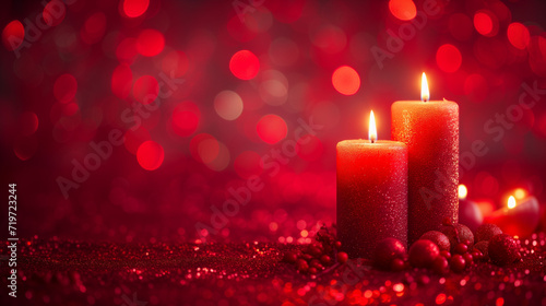 Two lit candles among glittering beads on a red background