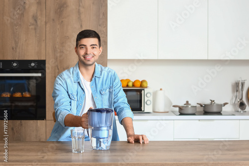 Young man with filter jug a...
