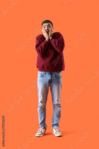 Afraid young man on orange ...