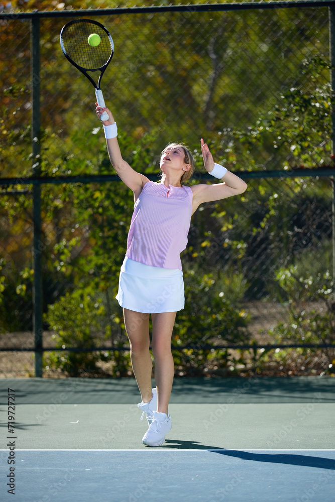 A girl exercises on a tennis court