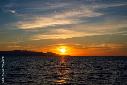 Sunset at Aegean sea at Zakynthos island in Greece. Sun setting behind the mountain © Arpan