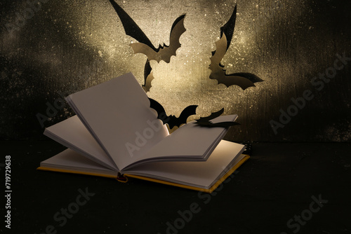 Open book with paper bats a...