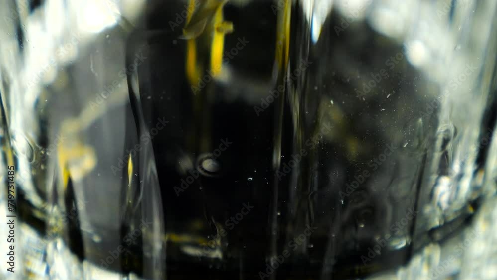 Whiskey is poured into a glass. Slow motion. Whiskey is poured into a glass. Slow motion.