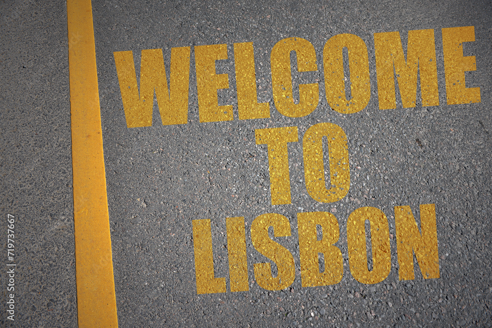 asphalt road with text welcome to Lisbon near yellow line.