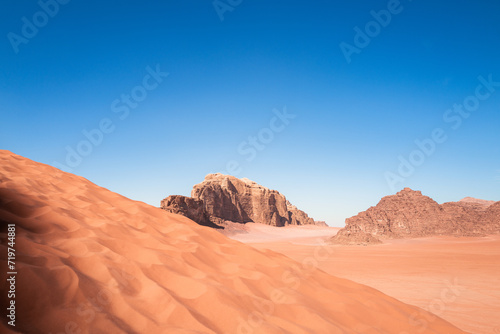 Scenic view of Arabic   Middle Eastern desert against clear blue sky with dune in foreground. Mountain in background and no clouds. Copy space no people