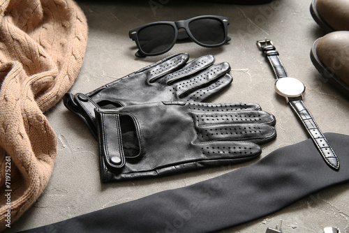 Composition with leather male gloves and stylish accessories on grunge background