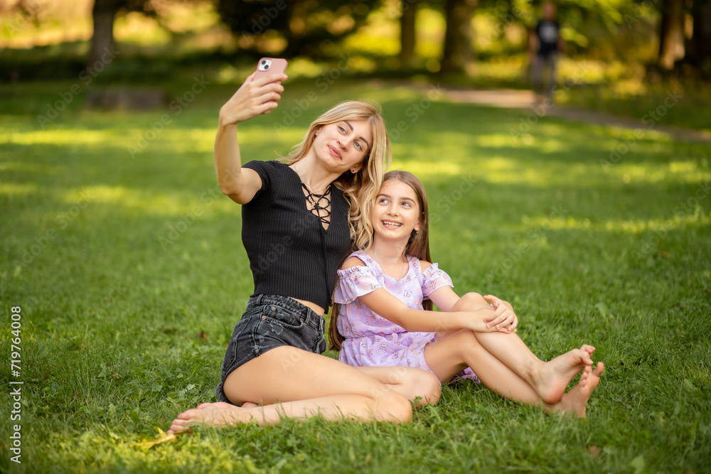 Mother and daughter taking a selfie in the park