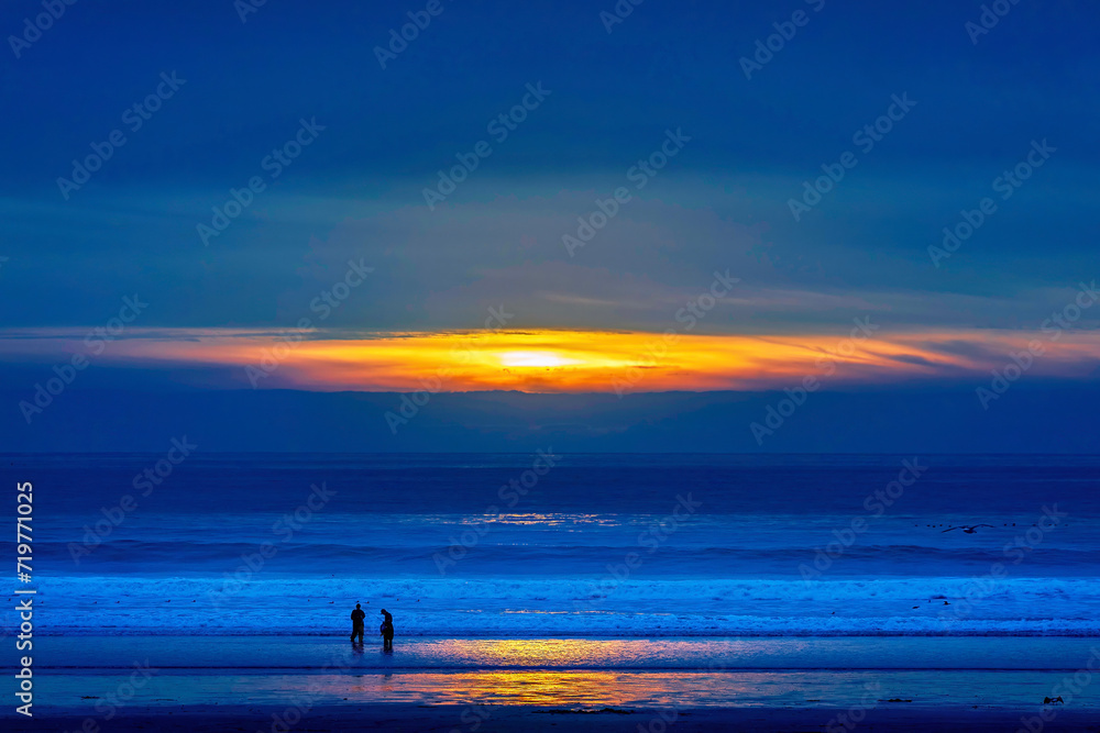 People standing on the beach at blue hour, sunrise, sunset, 