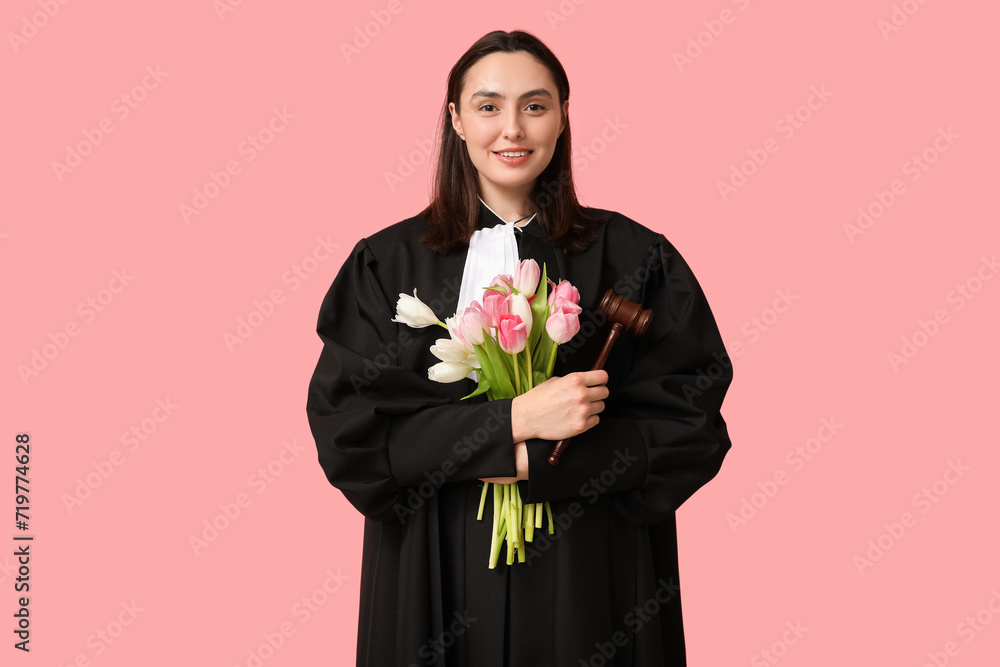 Portrait of young female judge with bouquet of flowers on pink background. International Women's Day Portrait of young female judge with bouquet of flowers on pink background. International Women's Day