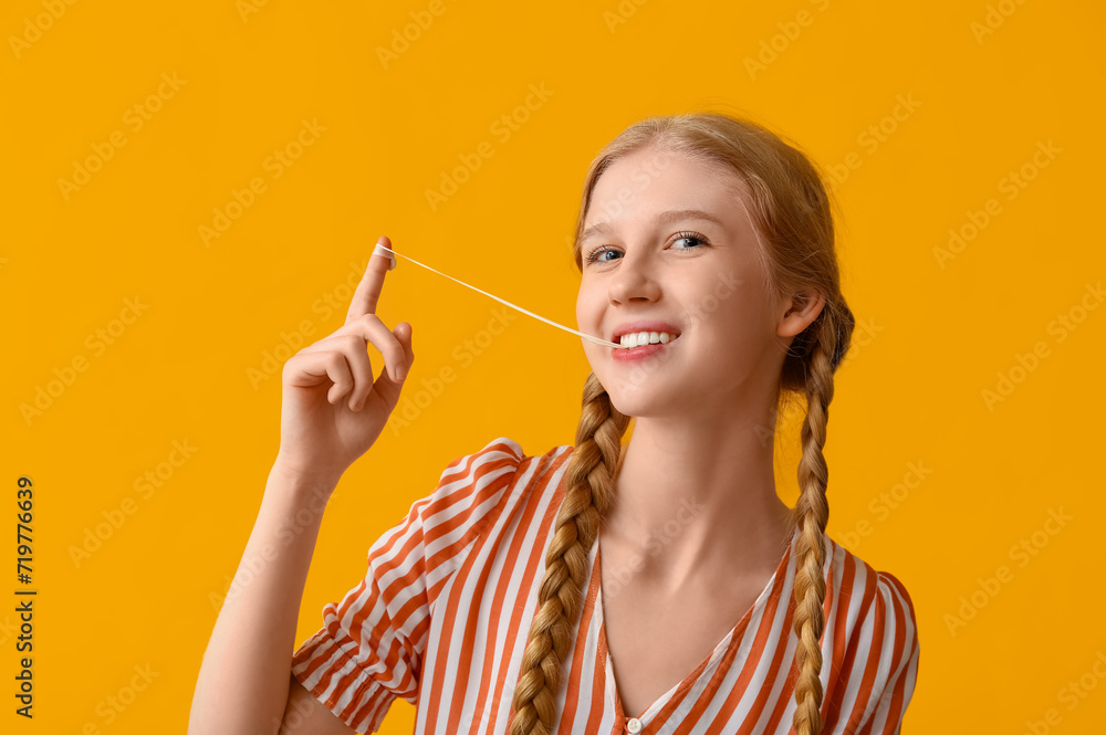 Teenage girl chewing gum on yellow background Teenage girl chewing gum on yellow background