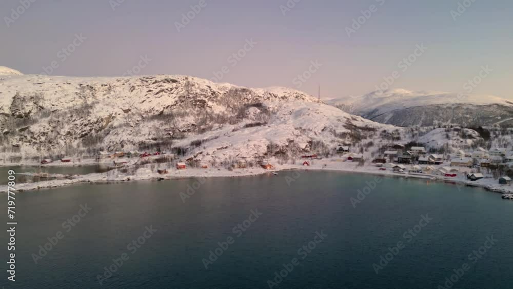 Ersfjordvegen village covered in snow during winter with calm waters, aerial view Ersfjordvegen village covered in snow during winter with calm waters, aerial view