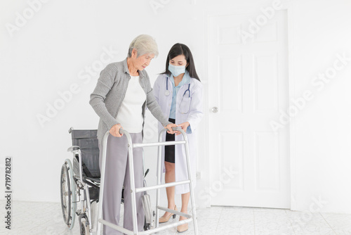 walk training and rehabilitation process, old asian stroke patient learning to uses walker with female asian doctor in hospital, elderly healthcare promotion