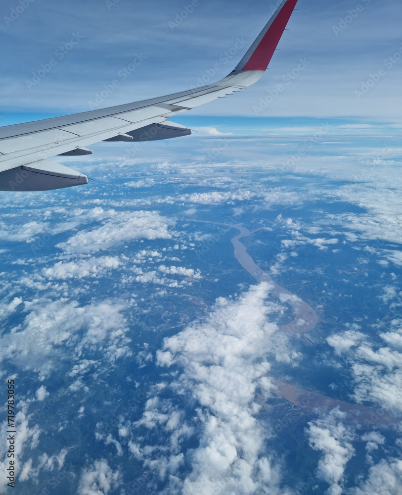 Airplane wing through the clouds in the sky. Airplane wing through the clouds in the sky.