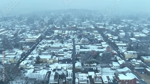 Snow covered town. High aerial orbit during snow storm above quaint historic American town. photo