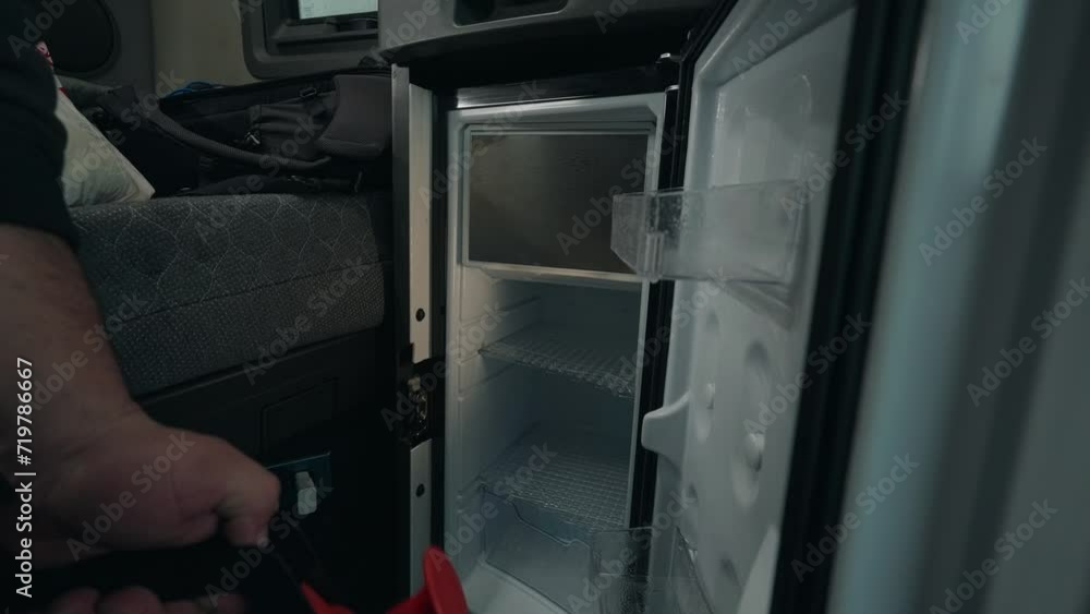Cleaning man uses a powerful spray to clean the interior fridge of a truck, ensuring a pristine and hygienic environment for transport. Cleaning man uses a powerful spray to clean the interior fridge of a truck, ensuring a pristine and hygienic environment for transport.