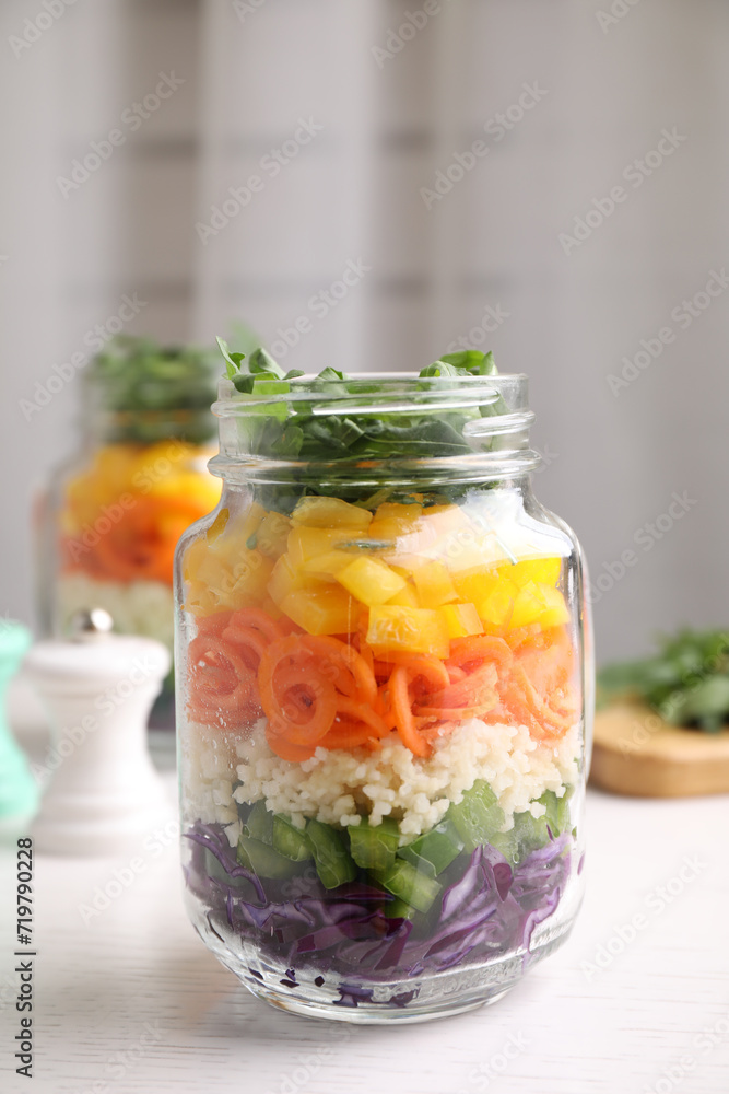 Healthy salad in glass jar on white wooden table Healthy salad in glass jar on white wooden table