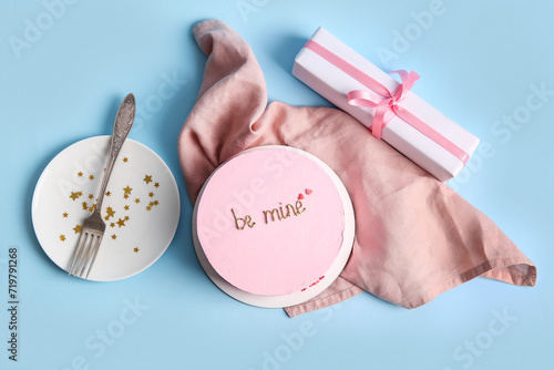 Pink bento cake with gift box and napkin on blue background. Valentine's Day celebration