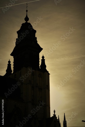 a large clock tower towering into the sky at dusk next to an airplane