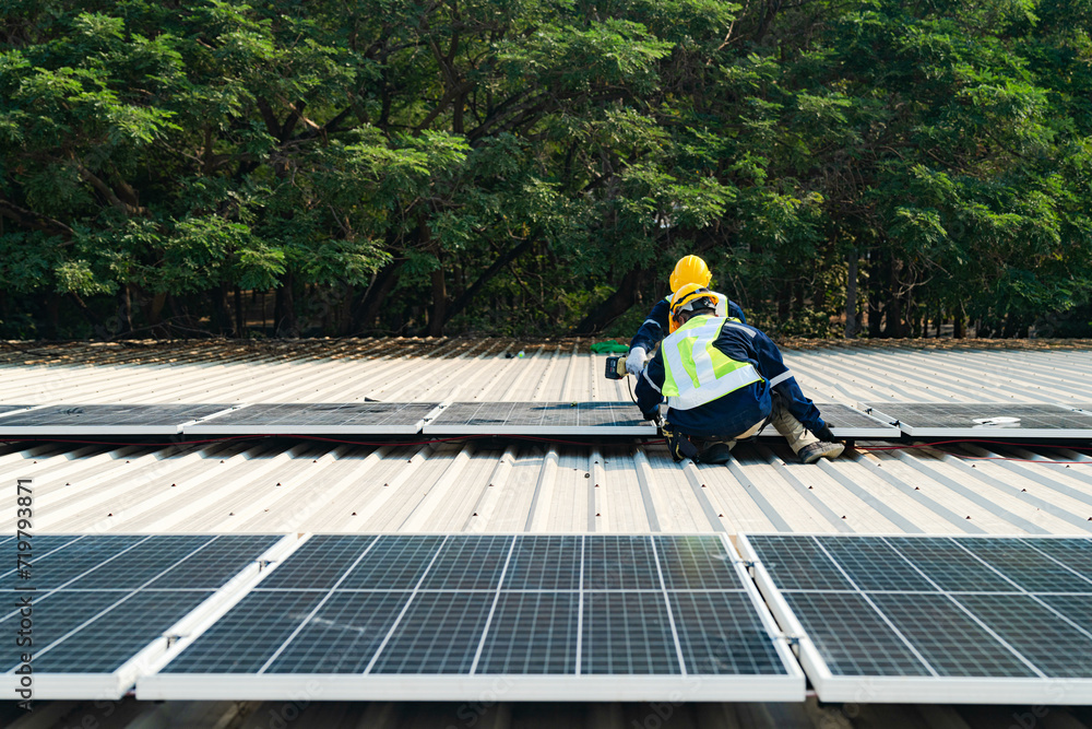 Worker Technicians are working to construct solar panels system on roof. Installing solar photovoltaic panel system. Men technicians carrying photovoltaic solar modules on roof. Worker Technicians are working to construct solar panels system on roof. Installing solar photovoltaic panel system. Men technicians carrying photovoltaic solar modules on roof.