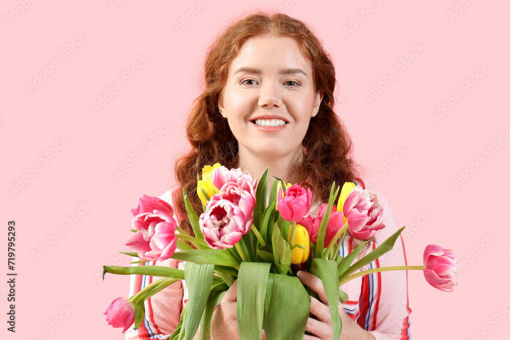 Happy young woman with bouquet of beautiful tulips on pink background. International Women's Day