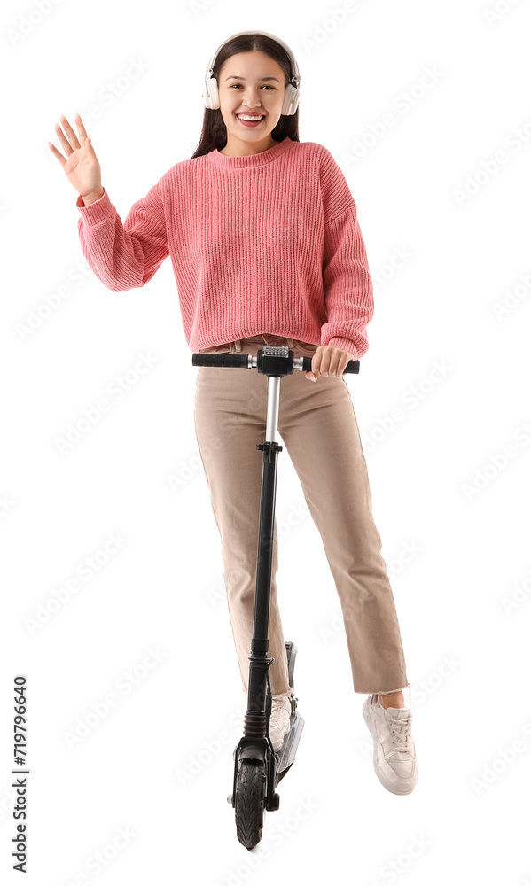 Happy young Asian woman in headphones riding modern electric kick scooter on white background Happy young Asian woman in headphones riding modern electric kick scooter on white background