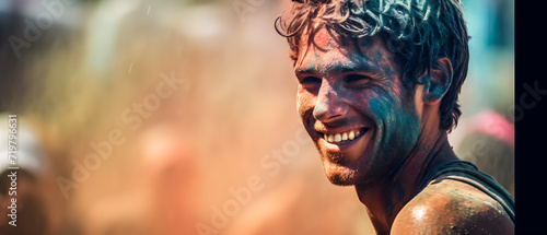 A smiling man joins the Holi festivities with colorful face paint