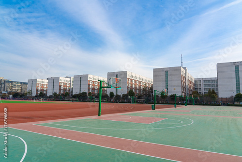 In the school yard:a basketball stands and school building.
