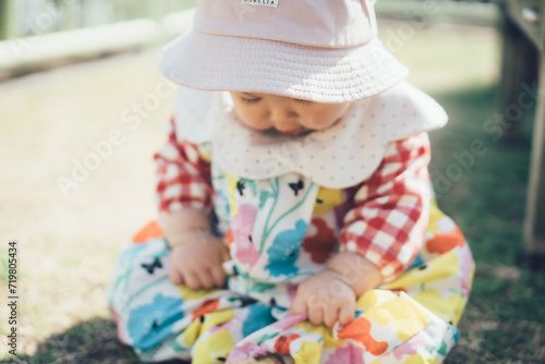 公園で帽子を被る赤ちゃん