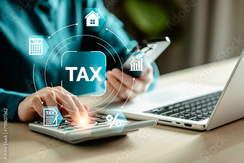 E-Filing, E-TAX, Taxpayer using a laptop to file taxes personal income, Tax Return form online for tax payment. Government, state taxes. Data analysis, paperwork, reports. Calculation tax return. photo