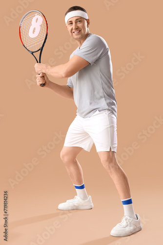 Middle-aged man in sportswear holding tennis racket with paper figure 8 on beige background. International Women's Day © Pixel-Shot