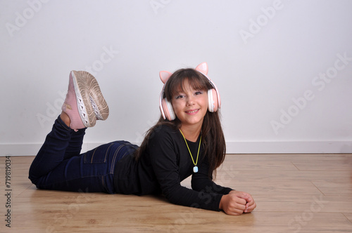 pré adolescente sorridente e feliz com fones de ouvido escutando músicas 