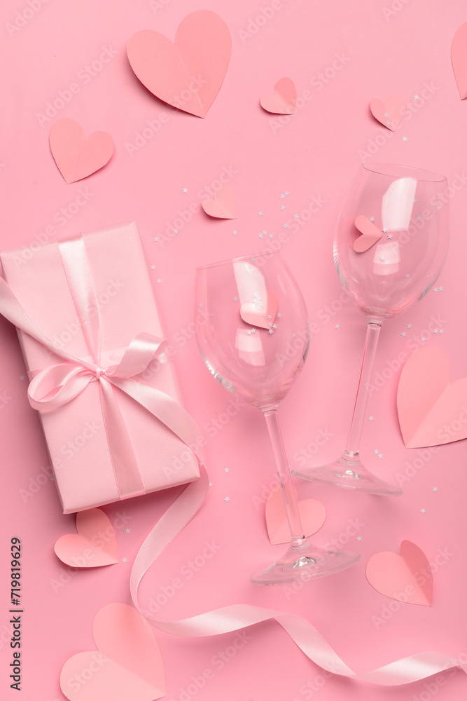 Fototapeta premium Composition with gift box, paper hearts and glasses for Valentine's Day celebration on pink background