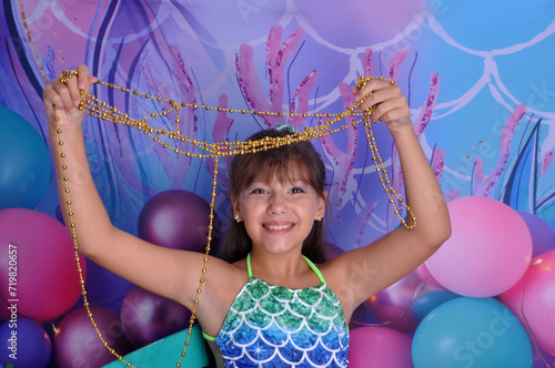 menina sorridente com roupa de sereia em cenário fundo do mar, ensaio de aniversário temático sereia linda  photo