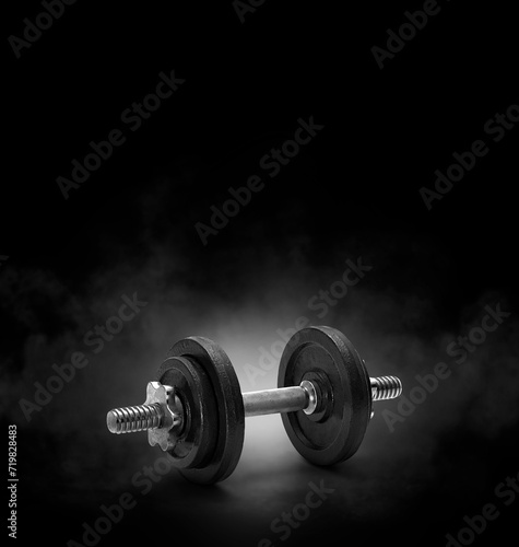black dumbbell with on black background with smoke