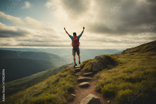 Hiker with raised hands standing on top of a mountain and enjoying the view.nature,climate.