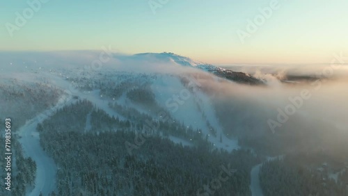 Drone circling toward the slopes of Levitunturi, misty winter morning in Lapland photo