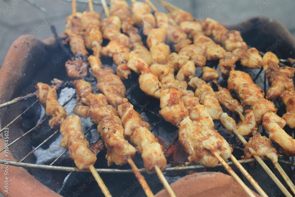 The process of grilling chicken satay on a traditional stove